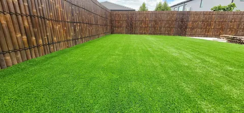 Artificial grass lawn beside bamboo screening