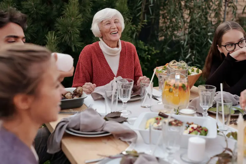 Family enjoying a meal together outside (stock photo)