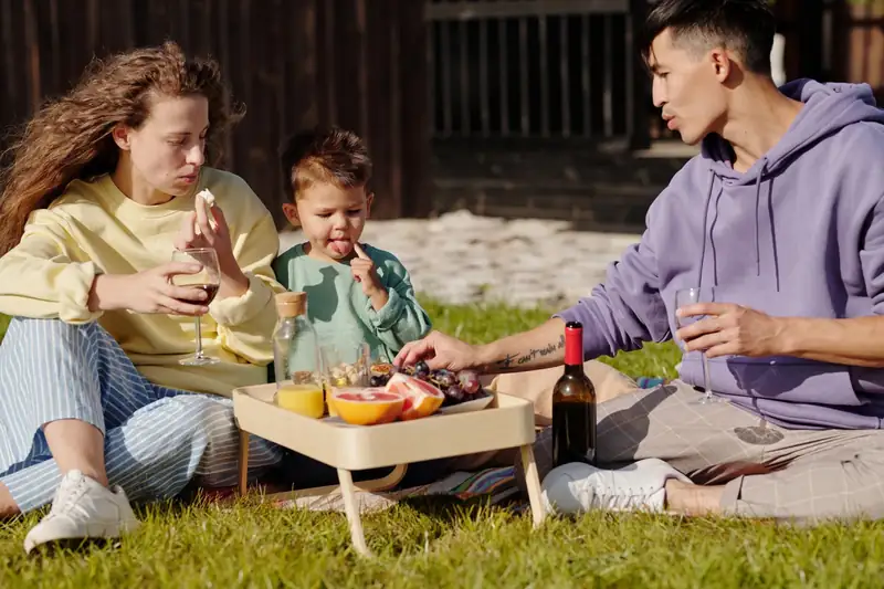 A family having a picnic on a backyard lawn (stock photo)