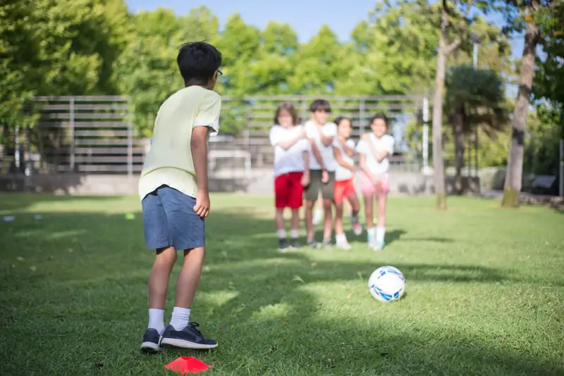 Kids playing soccer on a backyard lawn (stock photo)