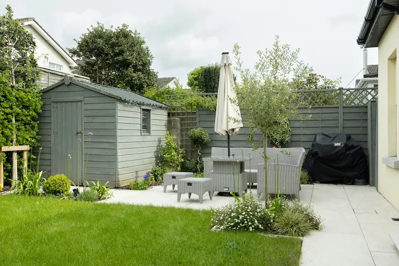 A natural lawn and paved patio in a small backyard (stock photo)